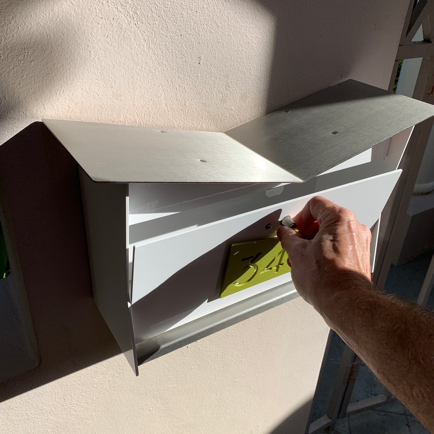Wall Mount Mailbox mounted to outdoor wall. ButterFly Box in arctic white and lemon lime
