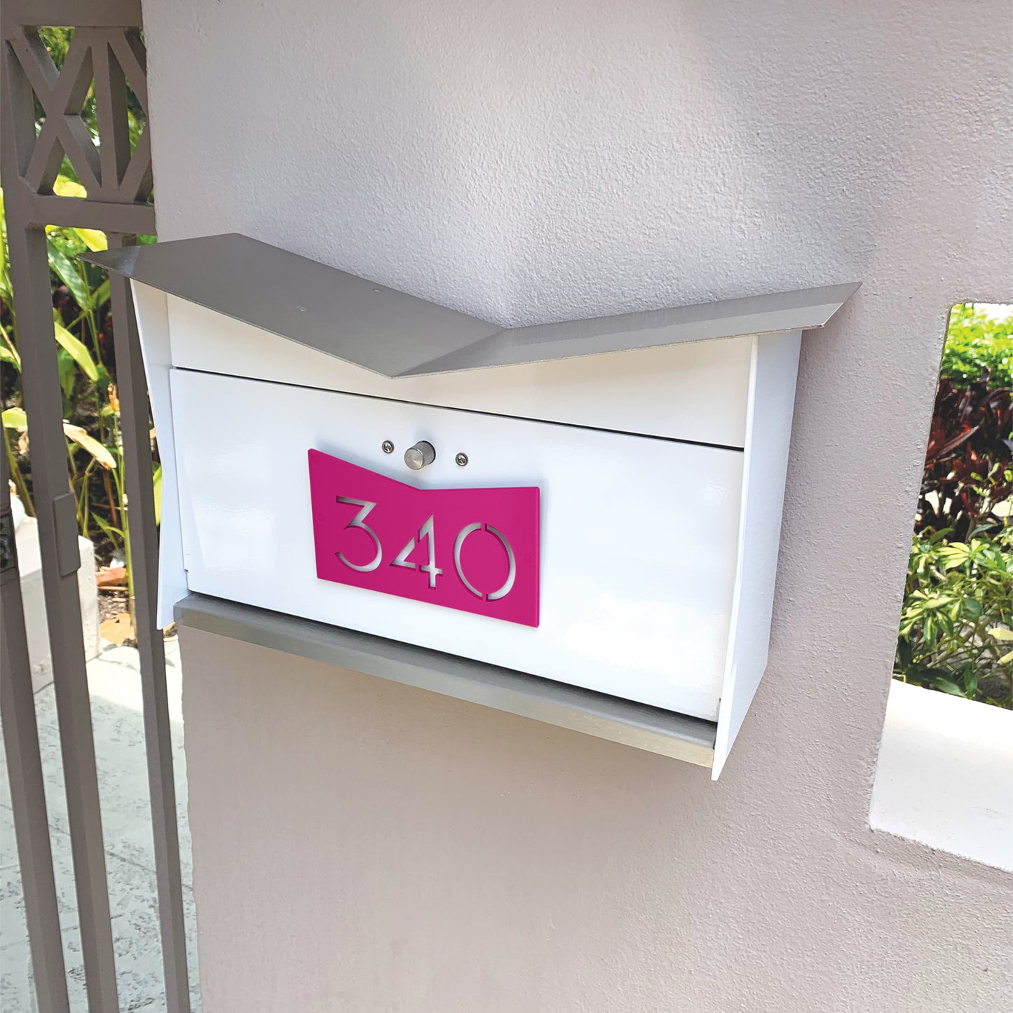 Wall Mount Mailbox mounted to outdoor wall. ButterFly Box in arctic white and neon pink