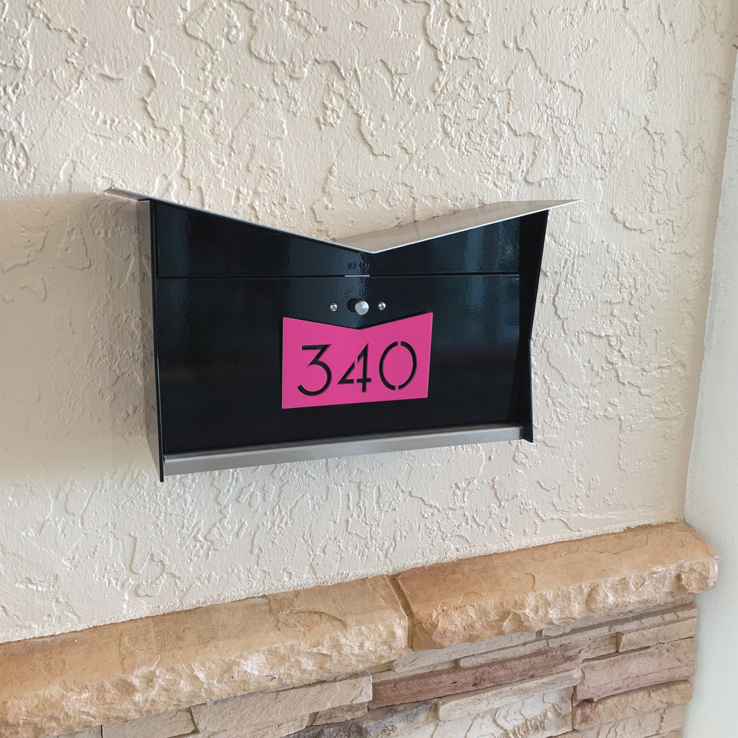 Wall Mount Mailbox mounted to outdoor wall. ButterFly Box in jet black and neon pink