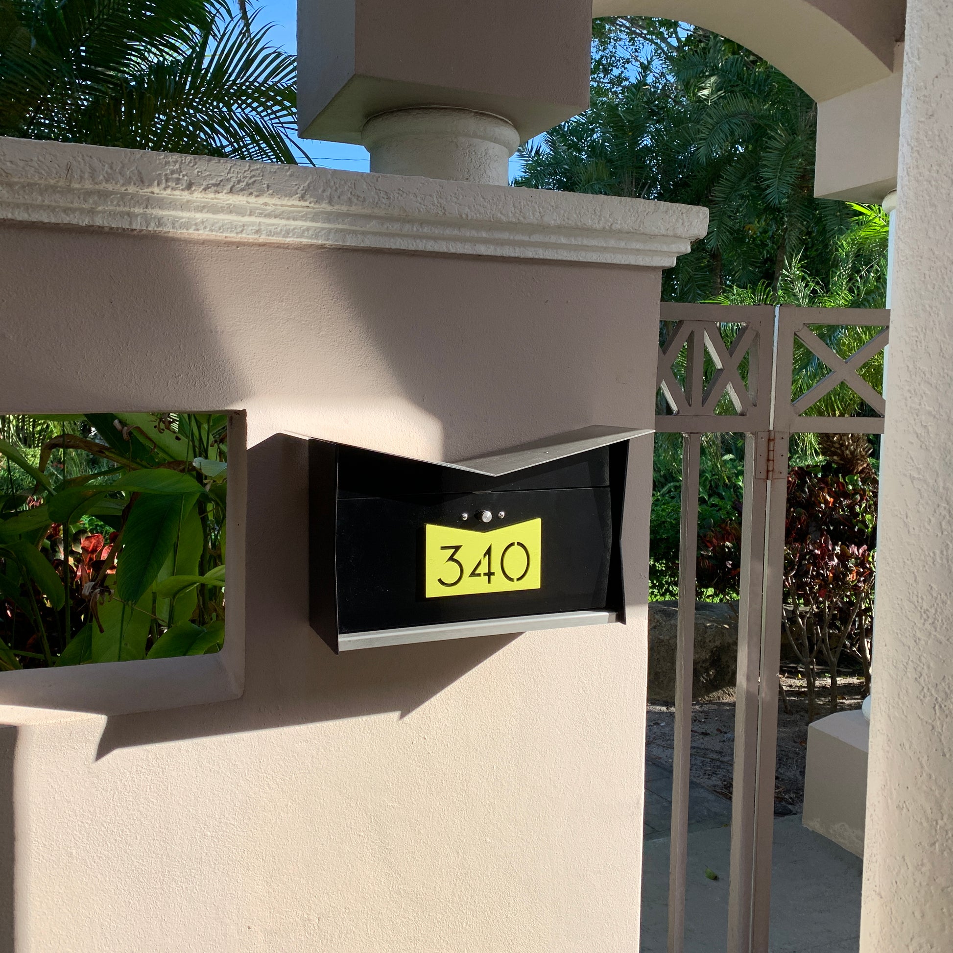 Wall Mount Mailbox mounted to outdoor wall. ButterFly Box in jet black and lemon lime