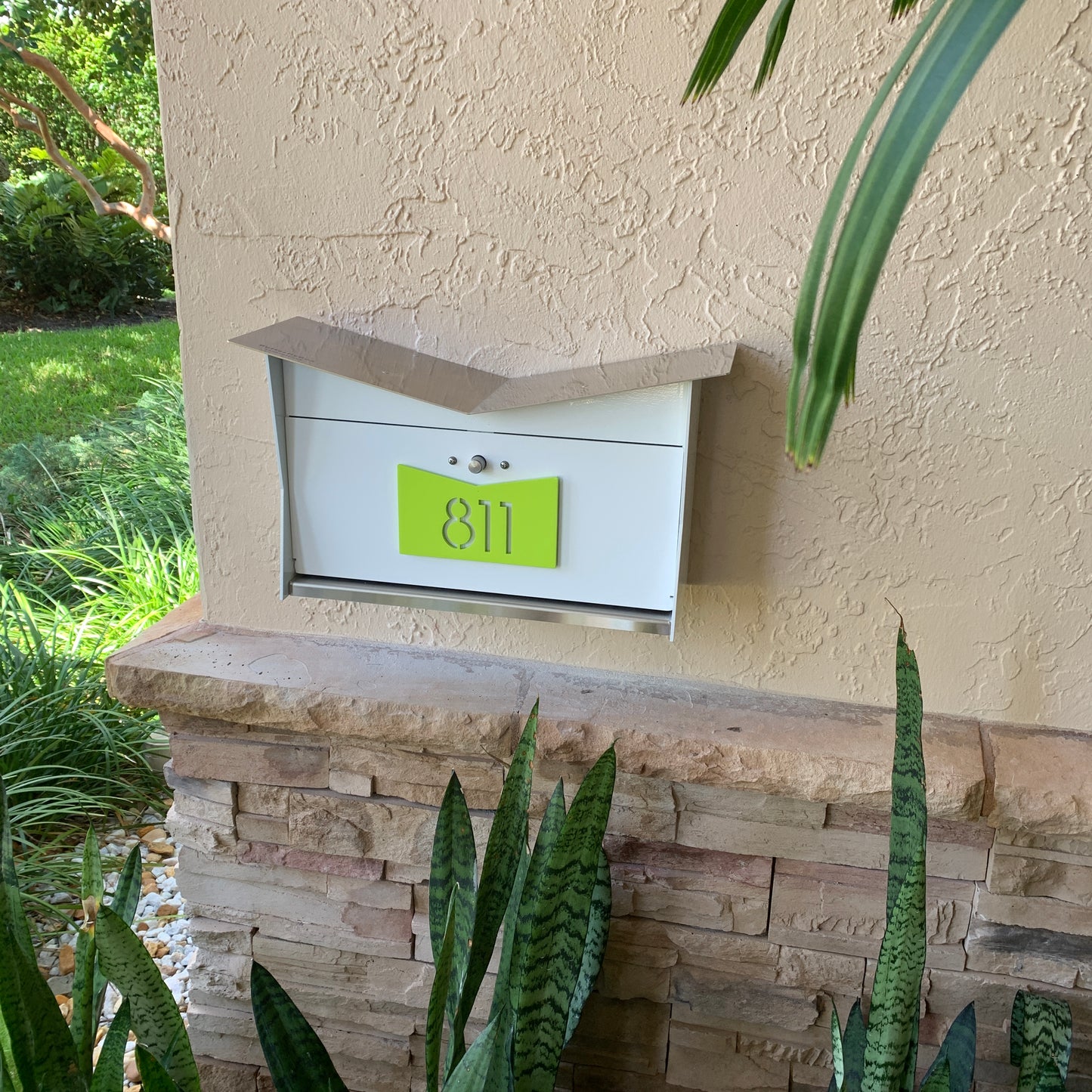 Wall Mount Mailbox mounted to outdoor wall. ButterFly Box in arctic white and lemon lime