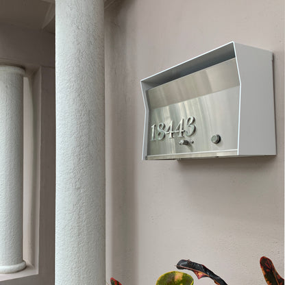 Wall Mount Mailbox mounted to outdoor wall. RetroBox in arctic white and stainless steel