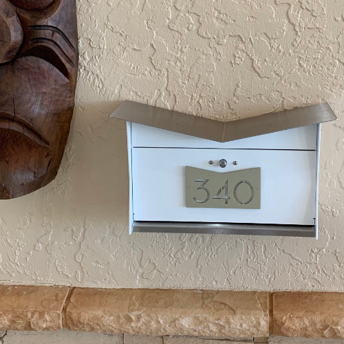 Wall Mount Mailbox mounted to outdoor wall. ButterFly Box in arctic white and mid-century gold